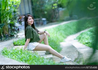 a portrait of beautiful happy asian woman traveler wearing brownish green dress stylish hipster Summer sunny lifestyle on the street outdoors at sunny summer day in park background