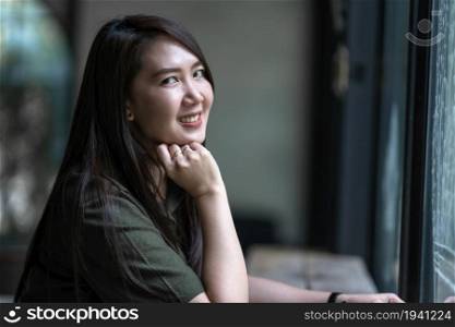 a portrait of beautiful happy smile asian woman traveler wearing brownish green dress stylish hipster Summer in coffee shop Cafe like the background