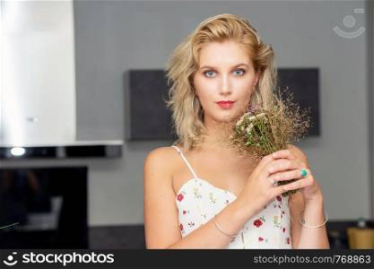 a portrait of beautiful young blonde woman with bouquet of flowers