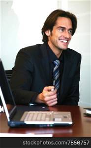 a portrait of businessman in front of laptop computer