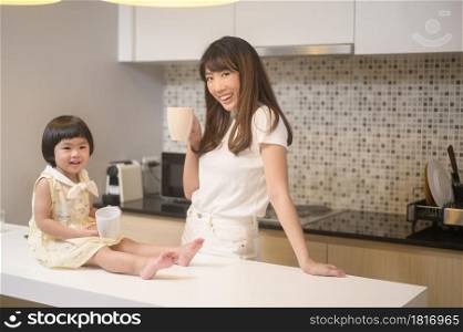 A portrait of happy mom and daughter in kitchen at home. Portrait of happy mom and daughter in kitchen at home