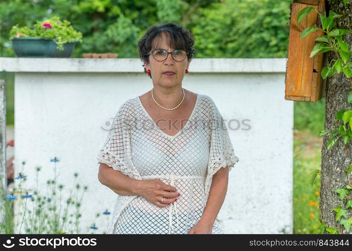 a portrait of mature brunette with glasses in the garden