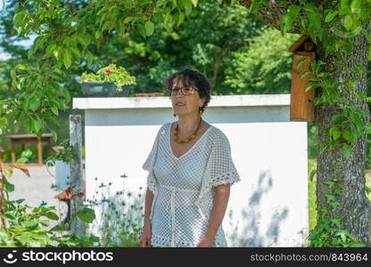 a portrait of mature brunette with glasses in the garden