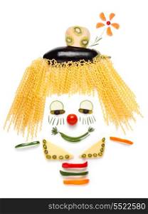 A portrait of shy clown made of vegetables and noodles.