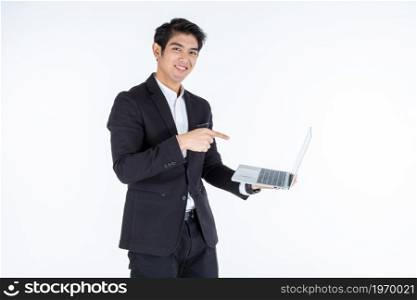 a portrait of successful Happy of asian young businessman a successful business hold laptop computer with pointing hand imagery panel isolated on white grey blank copy space studio background