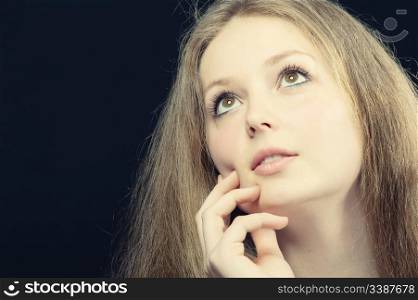 A portrait of the thoughtful girl. On a black background