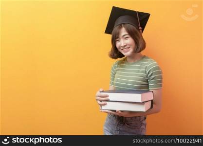 A portrait of young Asian student wearing graduation cap over studio background.. Portrait of young Asian student wearing graduation cap over studio background.