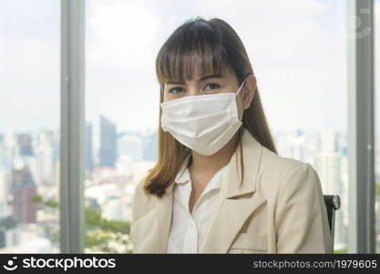 A Portrait of young beautiful Business Woman wearing a protective mask in modern office. Portrait of young beautiful Business Woman wearing a protective mask in modern office