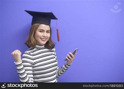 A portrait of young woman graduated over blue background . Portrait of young woman graduated over blue background