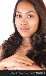 A portrait shoot of a beautiful Asian woman with long brunette curlyhair, looking onto the camera, over white.