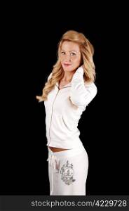 A portrait shot of a young beautiful woman with long blond hair, in awhite tracksuit standing for black background.