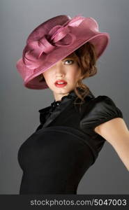 A portraot of a vintage sexy lady wearing black dress and colored hat.