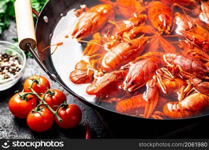 A pot of boiled crayfish and spices. On a black background. High quality photo. A pot of boiled crayfish and spices.