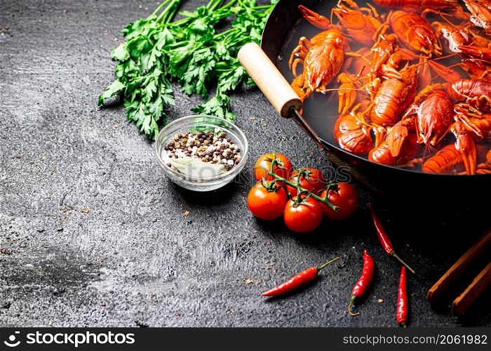 A pot of boiled crayfish and spices. On a black background. High quality photo. A pot of boiled crayfish and spices.