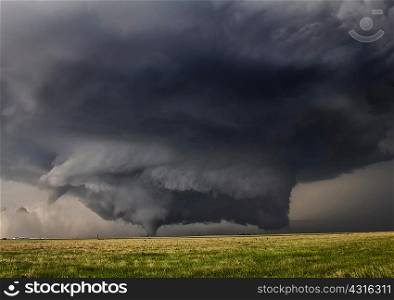 A powerful tornadic thunderstorm rolls over plains