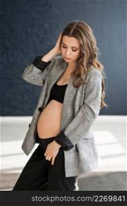 A pregnant girl with a bare big belly.. A photo of a pregnant girl in a photo studio 4117.