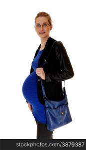 A pregnant woman in a blue dress and black coat and purse standingin profile, isolated for white background.