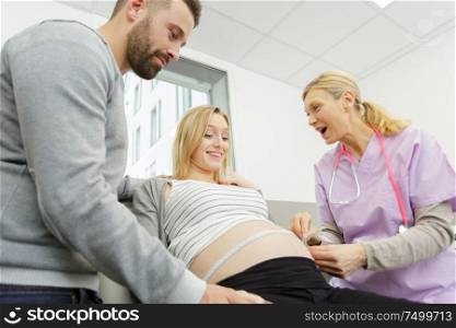 a pregnant woman measuring belly