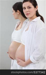 A pregnant woman standing in front of a mirror.