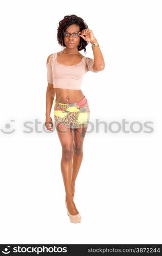 A pretty African American woman in a short skirt a t-shirt and heelsstanding in profile isolated for white background.