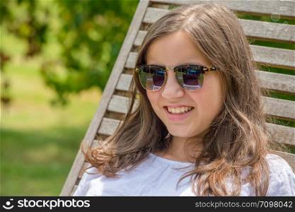 a pretty and smiling pre teen girl with sunglasses
