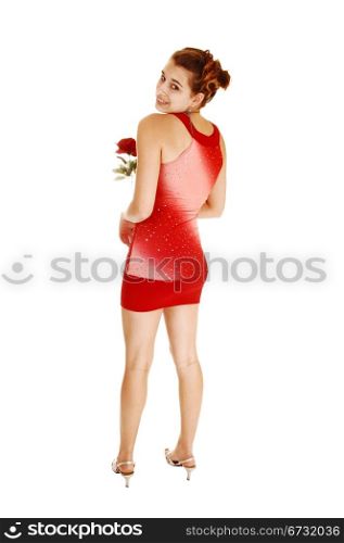 A pretty and young woman from the back in a red short and tight dressstanding in high heels for white background with her lovely figure.