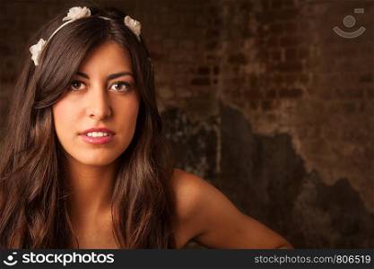 A pretty brunette girl sitting on leather sofa with brick wall background