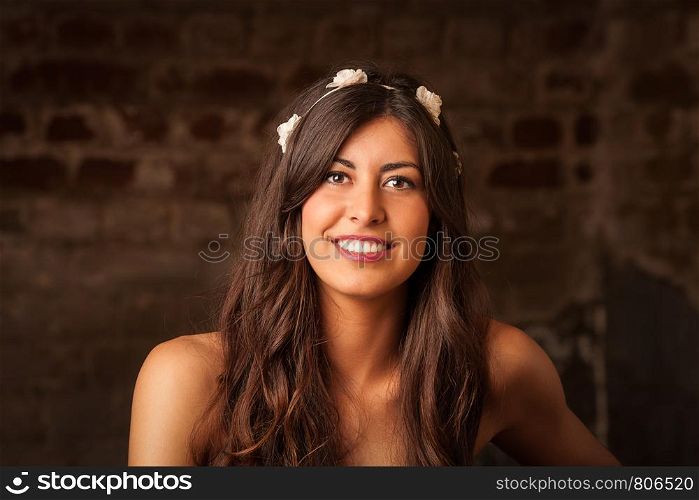 A pretty brunette girl sitting on leather sofa with brick wall background