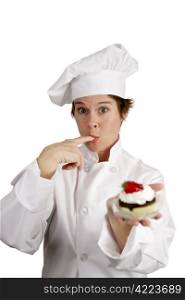 A pretty chef holding a strawberry cheesecake tart and licking whipped cream from her finger.