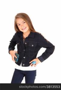 A pretty eight year old girl standing isolated for white background in jeans anda jean jacket, holding her purse.