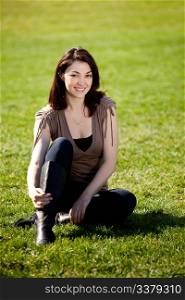 A pretty female isolated on a background of grass in a park