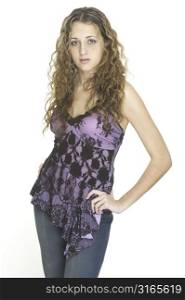 A pretty female model poses in jeans and a lacey purple top