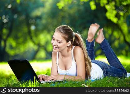 A pretty girl with a laptop in the park