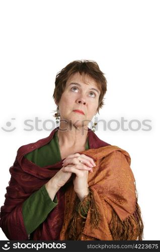 A pretty mature woman with her hands folded, looking heavenward as she pleads with God. Isolated on white.