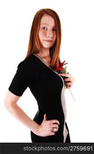 A pretty red haired woman in a black dress holding a red rose toher chest, looking into the camera, on white background.
