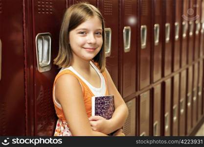 A pretty school girl leaning against her locker.