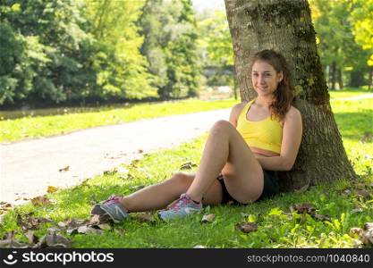 a pretty sporty girl relaxing and lying on the grass