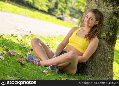 a pretty sporty girl relaxing and lying on the grass
