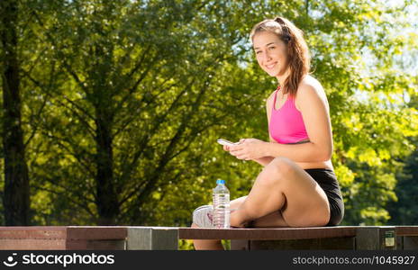 a pretty sporty girl relaxing and using the phone