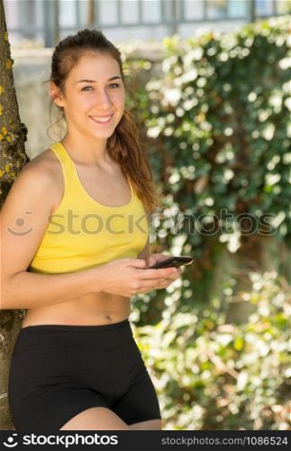a pretty sporty girl relaxing and using the phone