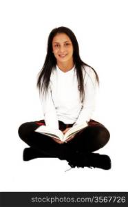 A pretty teenager girl in her school uniform and long black hair sitting onthe floor with a book in her hands for white background.
