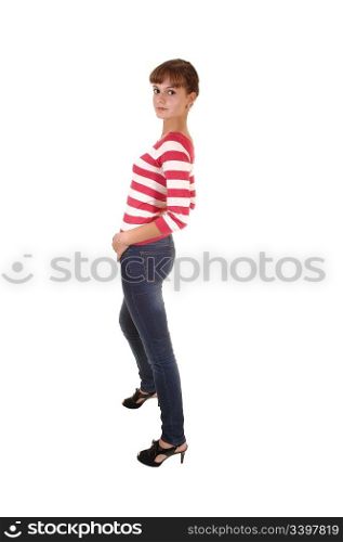 A pretty teenager girl in jeans and a striped sweater and high heelsstanding in profile in the studio, for white background.