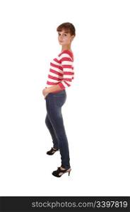 A pretty teenager girl in jeans and a striped sweater and high heelsstanding in profile in the studio, for white background.