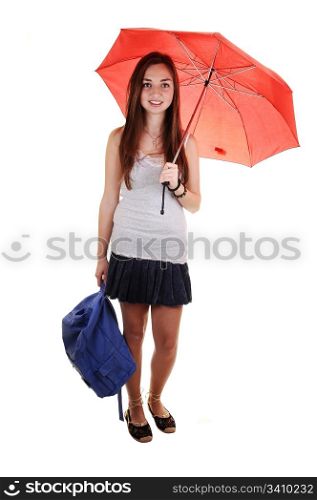 A pretty teenager in a short skirt and a blue backpack in her hand and an open umbrella over her shoulder standing in the studio for white background.