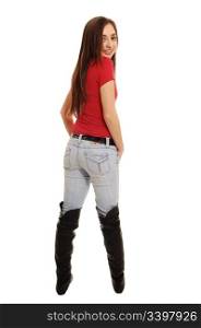 A pretty teenager standing in the studio in long boots and jeans, from theback with her long brunette hair, on white background.
