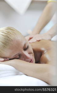 A pretty woman getting a shoulder and back massage at spa and wellness center