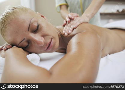 A pretty woman getting a shoulder and back massage at spa and wellness center