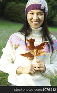 A pretty woman holding an autumn/fall leaf