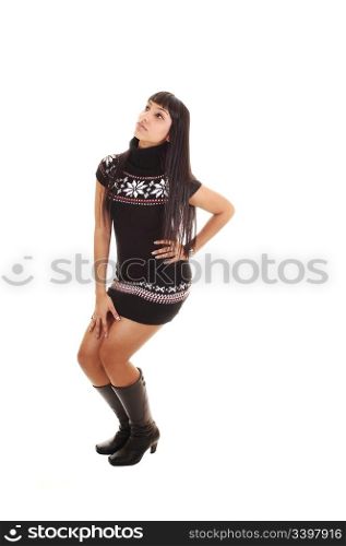 A pretty woman in a short brown dress and boots standing on thefloor showing her nice figure, on white background.