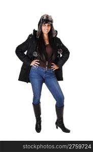 A pretty woman in jeans and boots and a winter coat with an fur capStanding relaxed in the studio, over white background.
